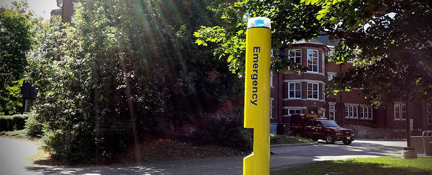 yellow emergency phone pole located across campus